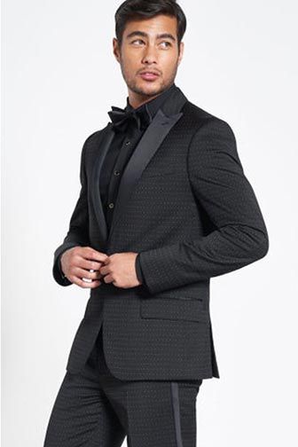 man wearing onyx dot tuxedo buttoning jacket 