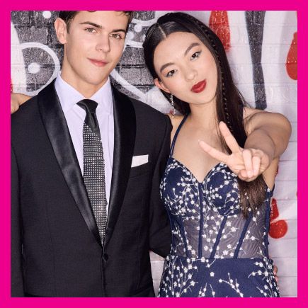prom couple posing in front of a mural