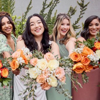 bridal party outside holding their bouquets in front of them