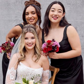 two bridesmaids posing with the bride