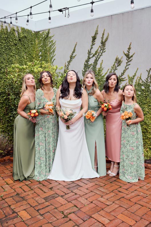 bridal party making kissy faces while holding bouquets