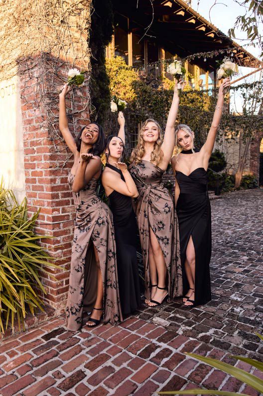 four bridesmaids holding bouqets above their heads
