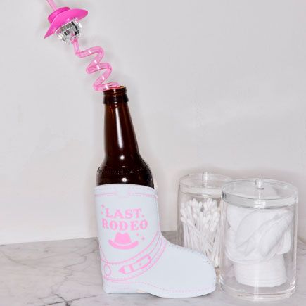 beer in a boot shaped beer loozie with a crazy straw in the bottle