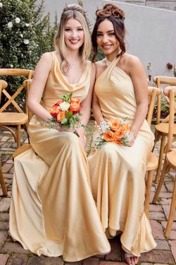 two bridesmaids sitting in chairs holding bouquets