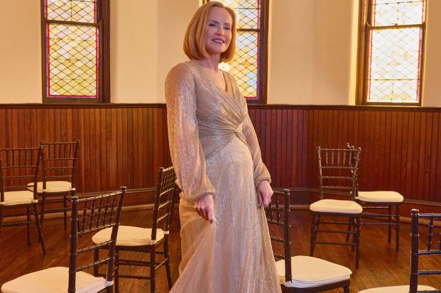 mother of the bride in occasion dress posing with chairs