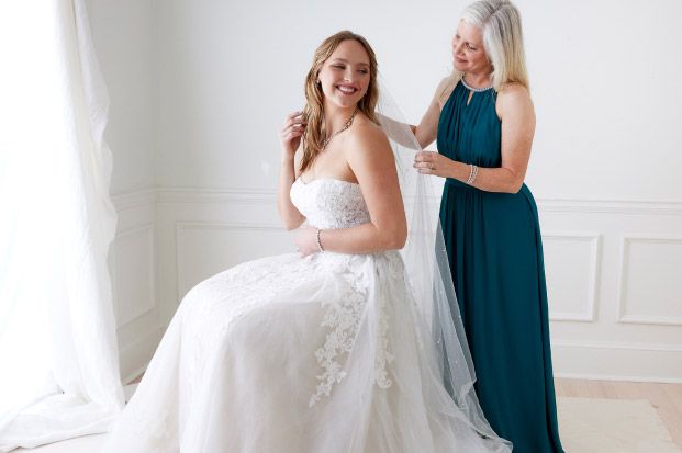 mother of the bride helping her daughter with her veil
