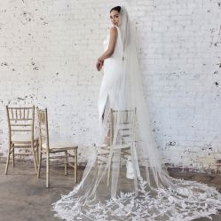 bride standing on a chair showing off her cathedral veil