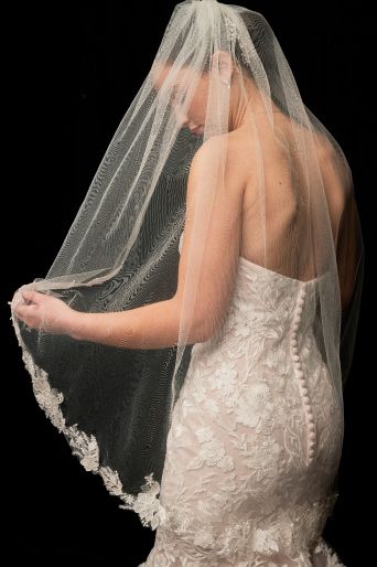 bride on black background wearing a mid-length veil