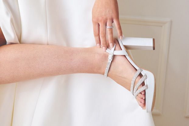 closeup of a bride adjusting her shoe