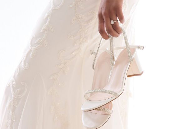 closeup of a bride holding her high heel shoes