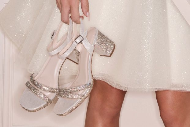 closeup of a bride holding her high heel shoes