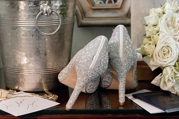 closeup of shiny high heel shoes on a table with a bouqet