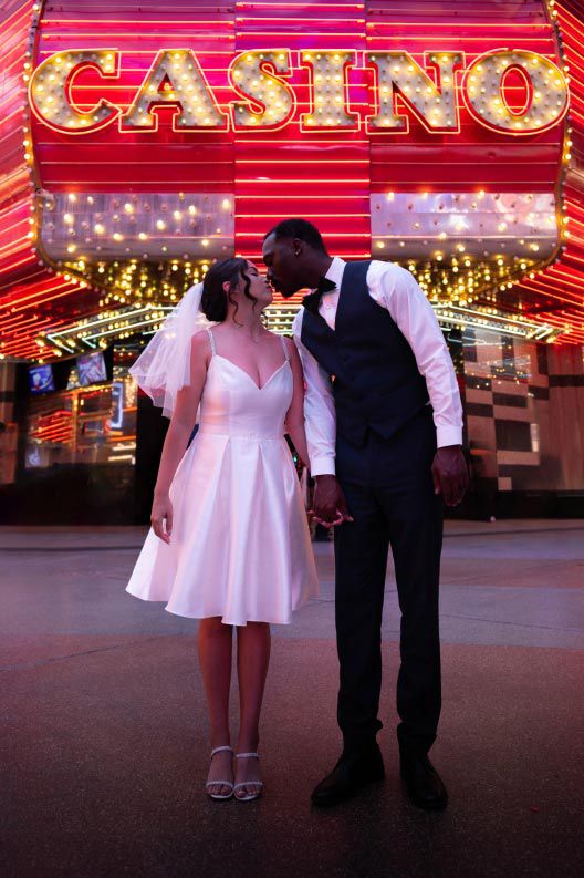 bride and groom kissing in las vegas in front of a casino