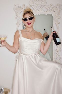 bride in a wedding dress holding a bottle of champagne