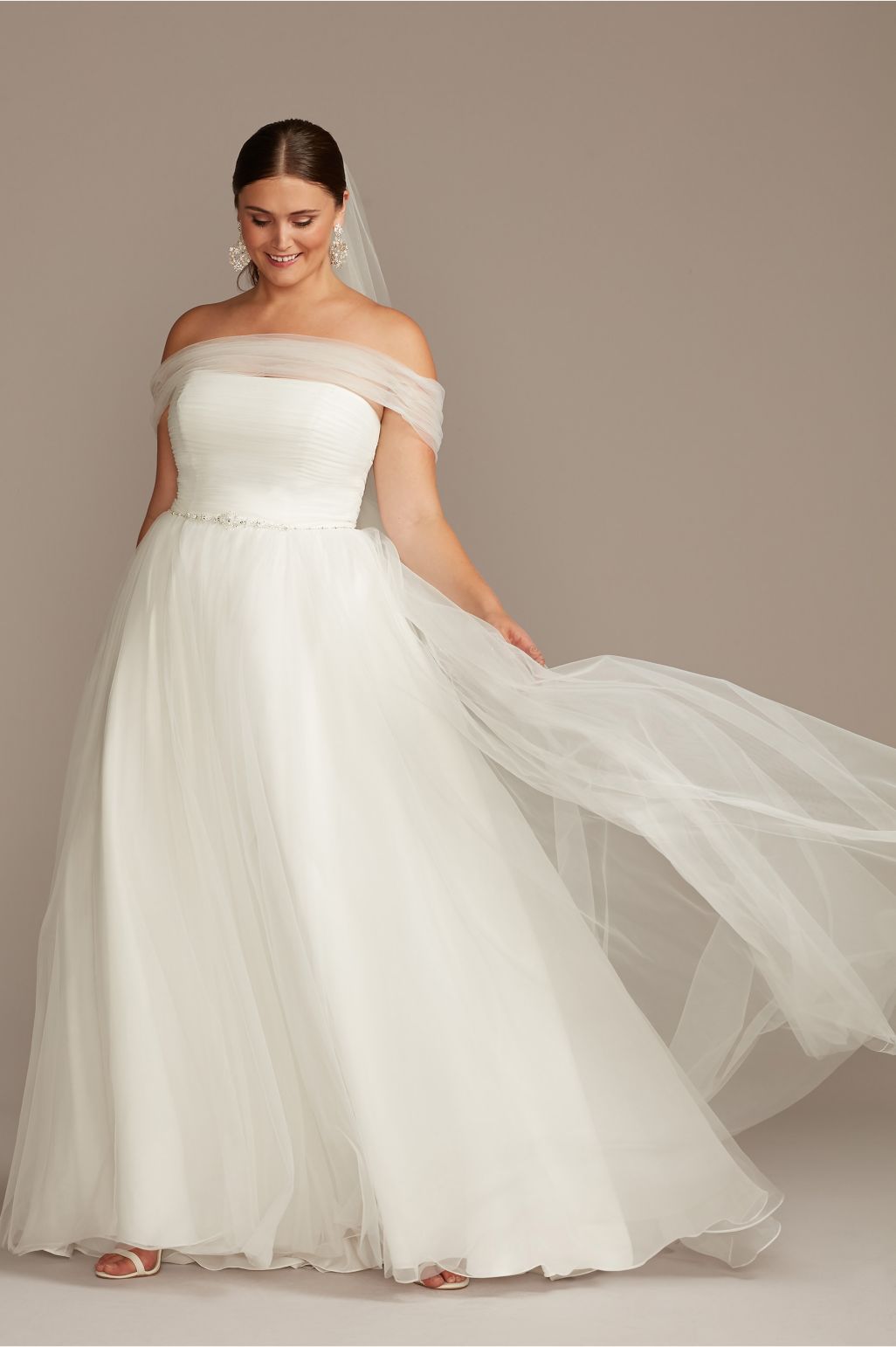 bride wearing wedding dress and holding her long veil
