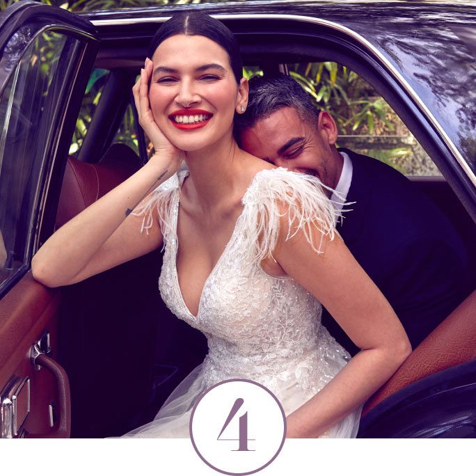 bride and groom sitting in a car with the door open and smiling