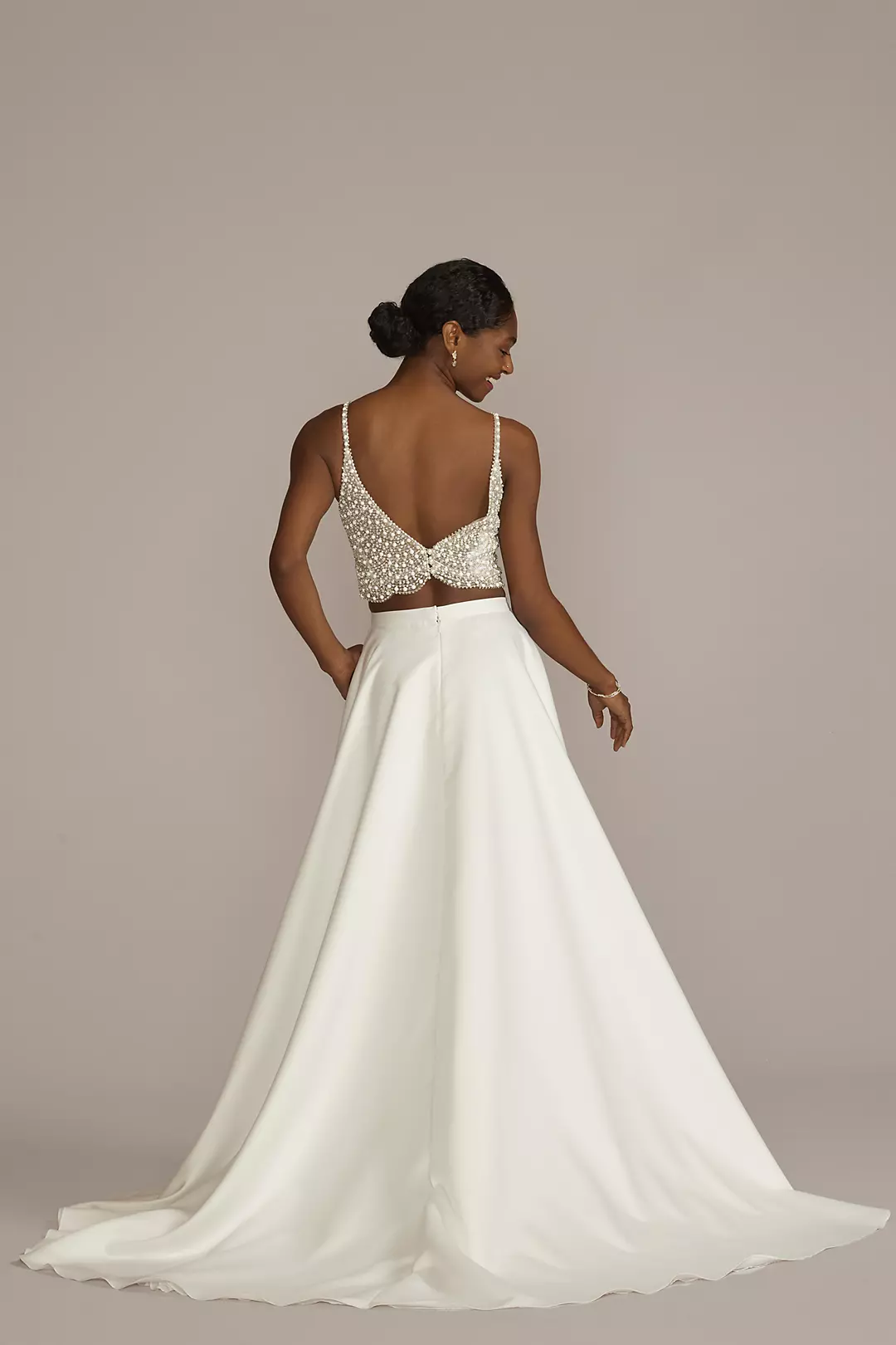 Separates wedding dress composed by a lace bodysuit with open back, a satin  crop top under it and a long satin skirt with pockets