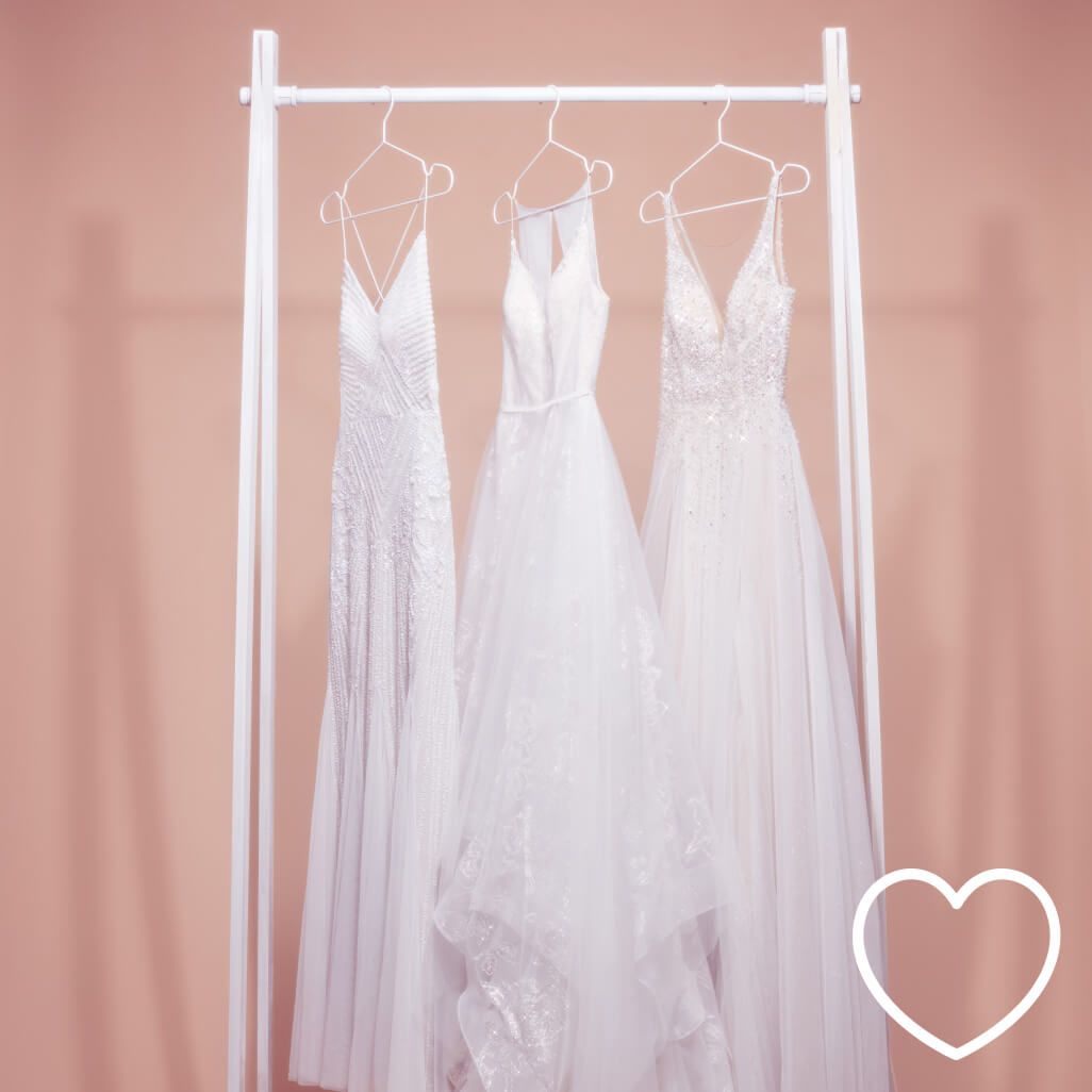 wedding dresses hanging on a dress rack