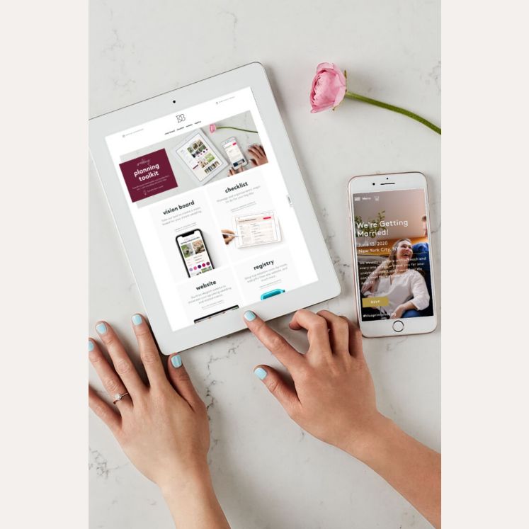 hands scrolling on an ipad next to a cell phone on a table