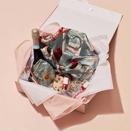 box filled with champagne, robe, and lip gloss