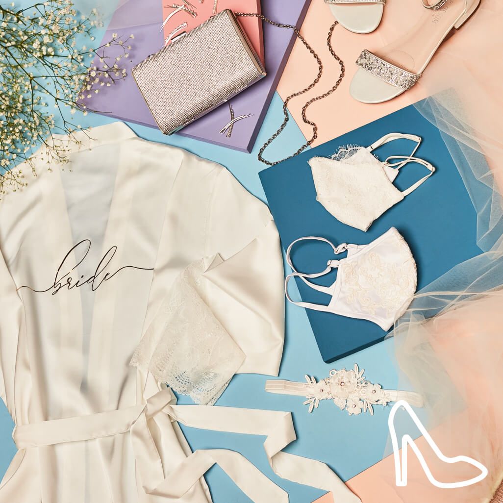 bride robe on a table with a pocketbook, garter, masks, shoes, and accessories 