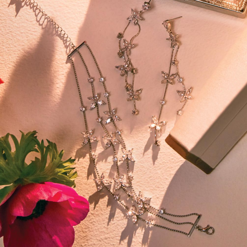 shoes, jewelry, and a handbag on a table with flowers