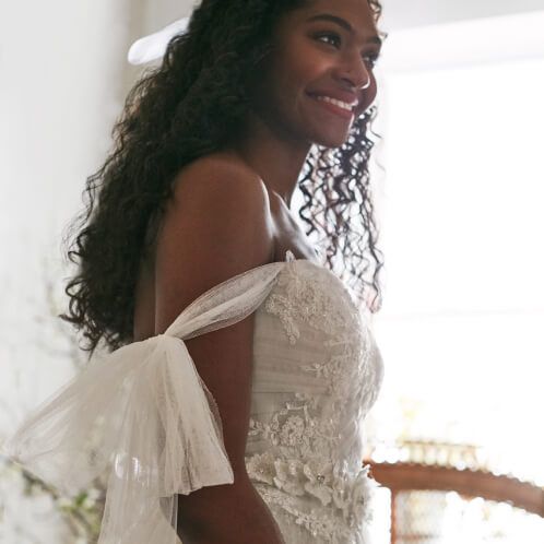 closeup of smiling bride standing in front of a window