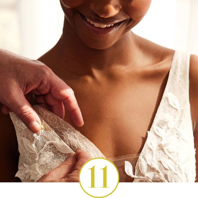 bride having her gown altered by stylists