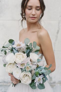 bride holding flower bouquet looking over shoulder