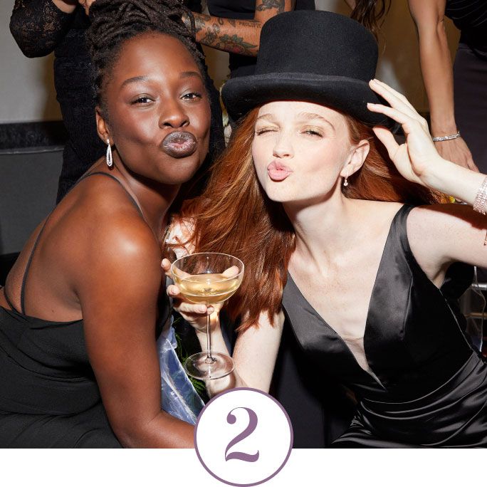 2 bridesmaids making kissy faces and holding a glass of champagne