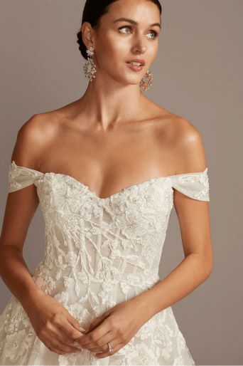 closeup of bride wearing a wedding dress with appliques and beading