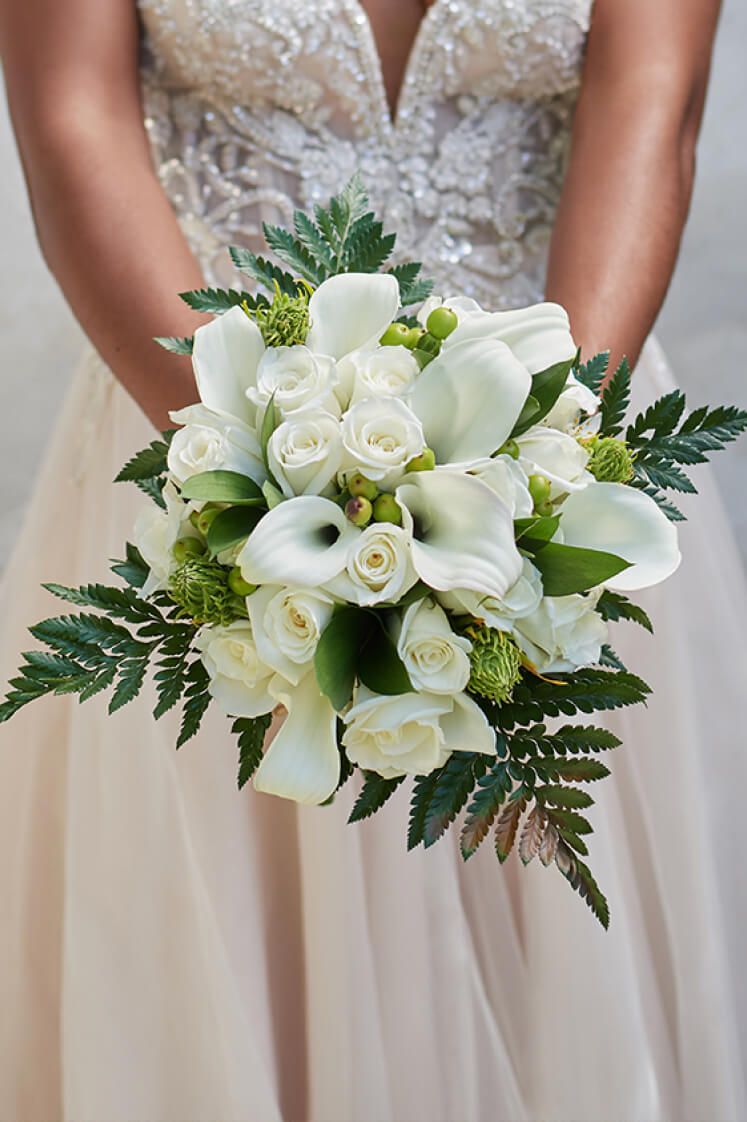 bride holding a bouquet of white roses with both hands