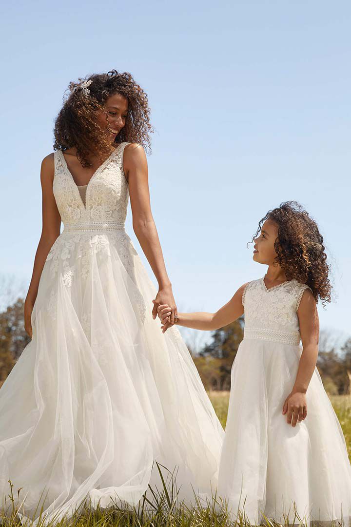 bride walking and holding hands with flower girl