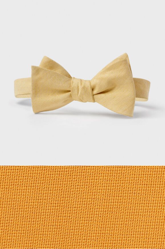 butter colored bow tie on top of a butter colored fabric swatch